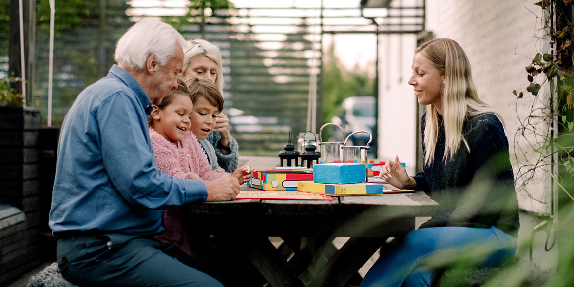 grandparents, mother and children sat playing board games